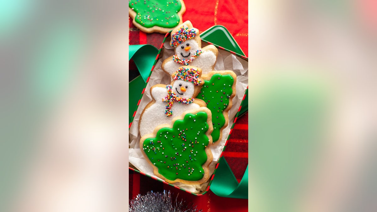 two snowmen and two Christmas tree in a tin