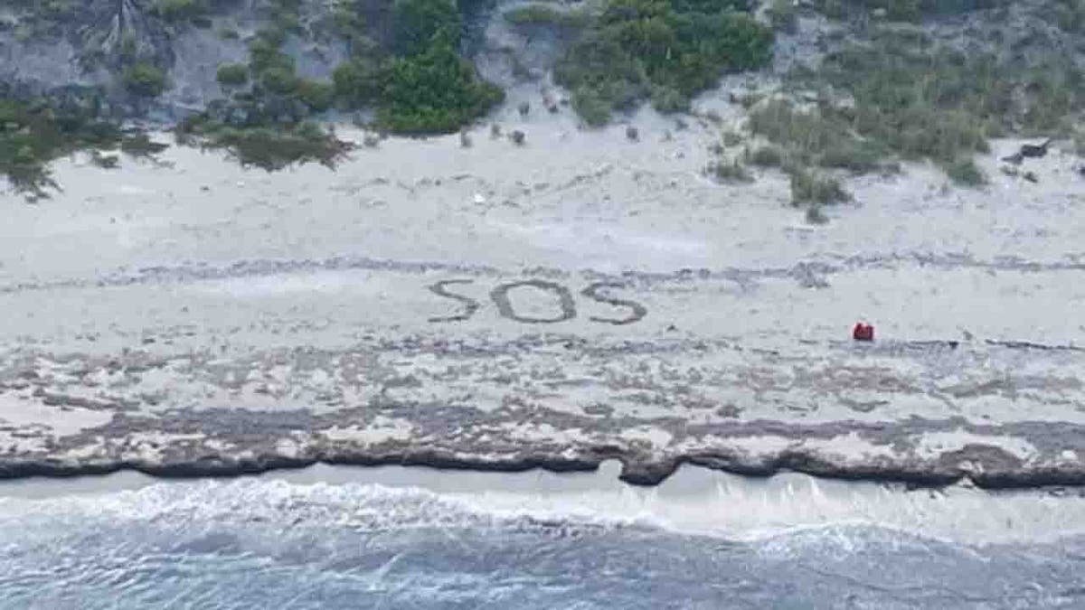 SOS written in sand on beach