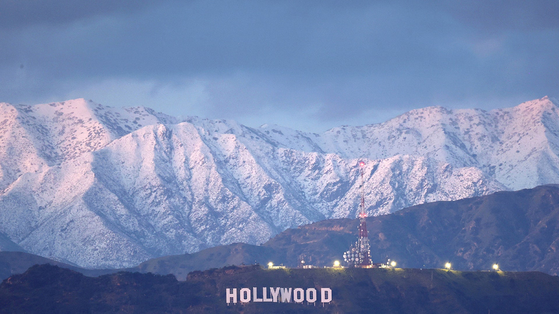 The Hollywood sign stands in front of snow-covered mountains