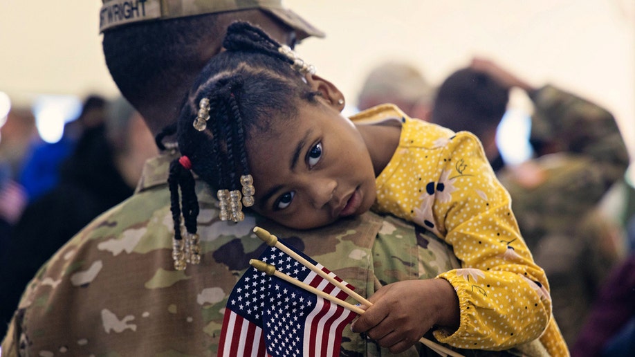 una niña abraza a un soldado