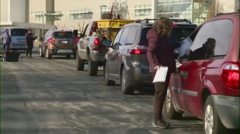 Cars are seen lined up at a food giveaway event