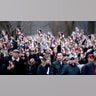 Mourners hold up a program with a photo of Lisa Marie Presley on the front lawn of Graceland