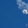 The suspected Chinese spy balloon drifts to the ocean after being shot down
