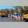 Children from The Covenant School hold hands as they are taken to a reunification site after a mass shooting
