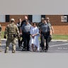 Danelo Cavalcante is escorted out of the Pennsylvania Police Headquarters
