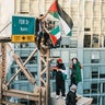 Pro-Palestinian protestors wave a flag above the Brooklyn Bridge