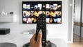 Woman with remote control watching streaming content