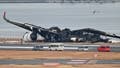 Officials look at the burnt wreckage of a Japan Airlines (JAL) passenger plane on the tarmac at Tokyo International Airport at Haneda in Tokyo on January 3, 2024. Two probes have been launched into Tuesday&rsquo;s deadly plane crash where five people died after a passenger jet collided with a Coast Guard turboprop at a Tokyo airport.