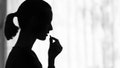 Silhouette of a young woman taking pill medication.
