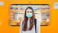 Woman wearing a surgical mask standing in front of the moving train