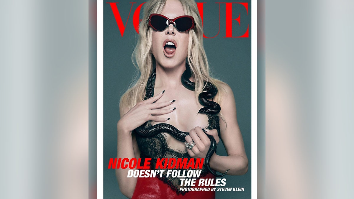 Nicole Kidman com sutiã de renda preto com tênis no ombro, boca aberta e óculos escuros pretos na capa da Vogue Austrália