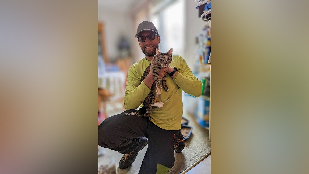 Murrow smiling while holding cat