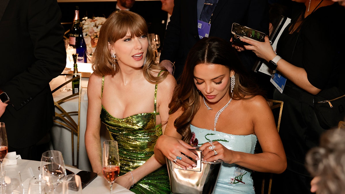 Taylor Swift e Keleigh Teller sentam-se à mesa do Globo de Ouro