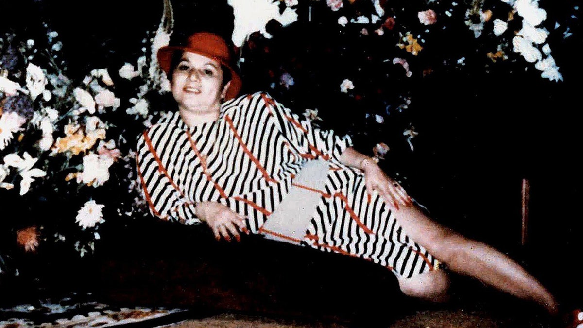 Griselda Blanco with black and white striped dress and red hat