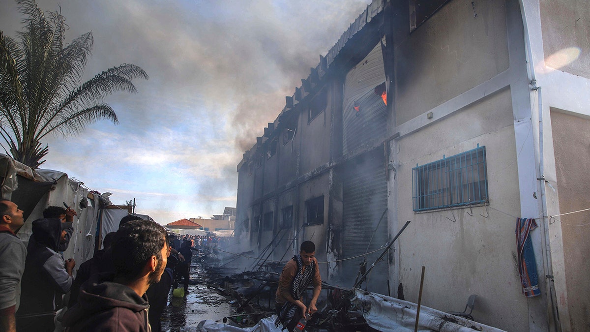 Palestinians near a burning building