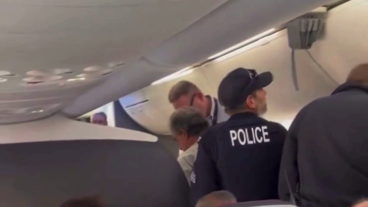 Keith Edward Fagiana being escorted off the plane