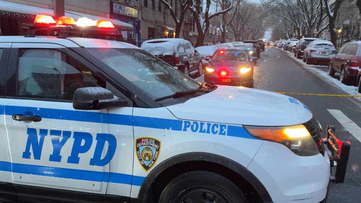 An NYPD vehicle helps block off a street where a shooting took place