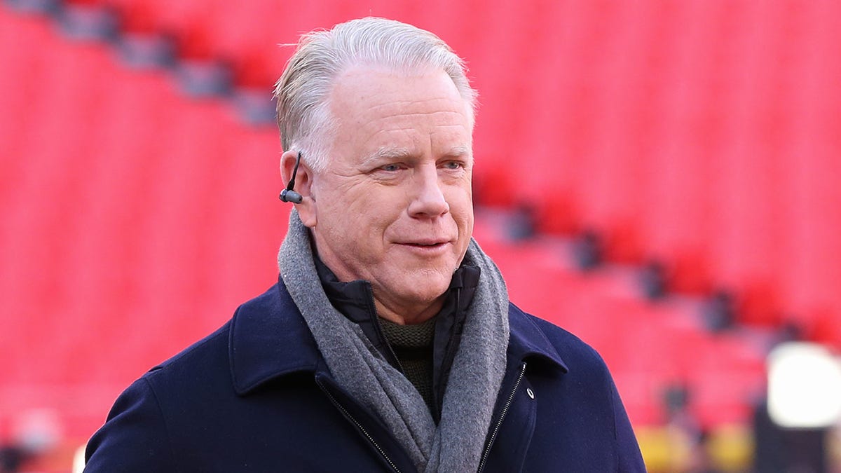 Boomer Esiason stands on the football field