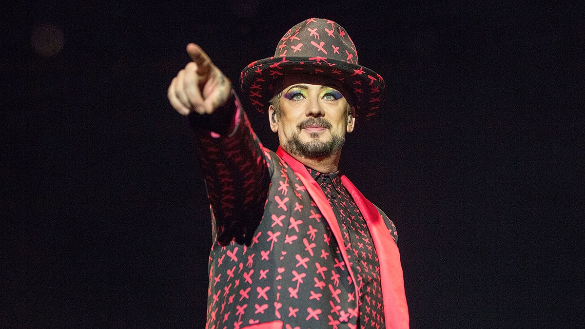 Boy George on stage wearing red and black