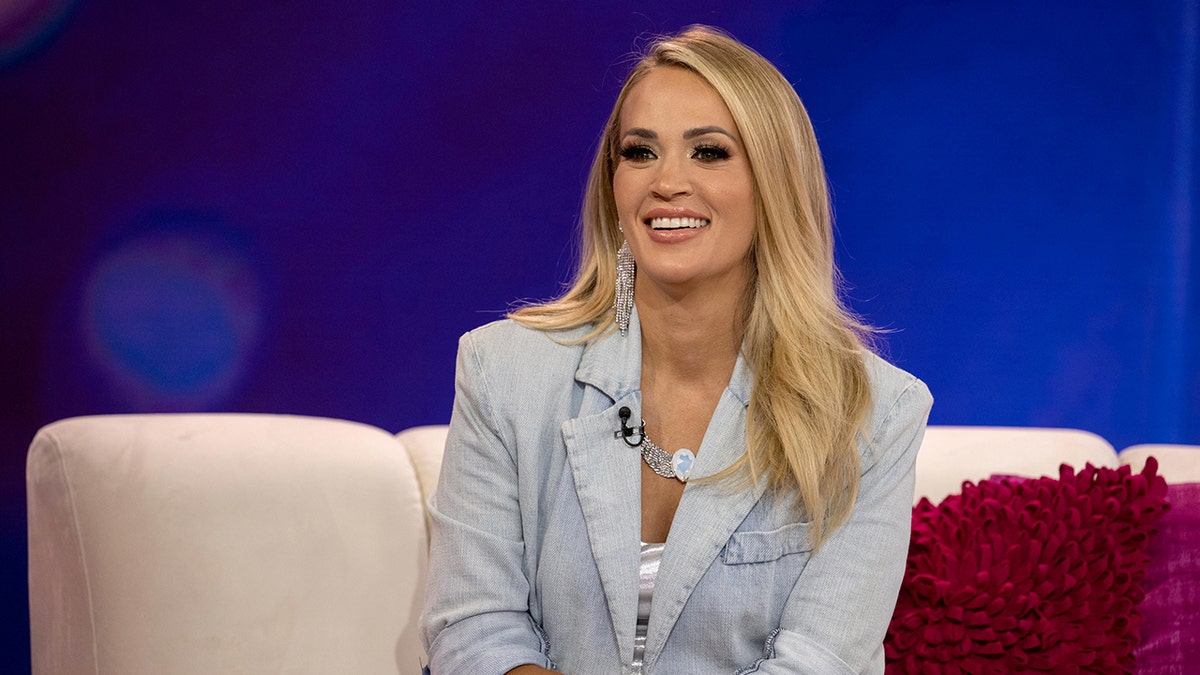 Carrie Underwood smiling on a TV set