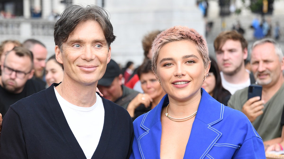 Cillian Murphy and Florence Pugh pose on a red carpet
