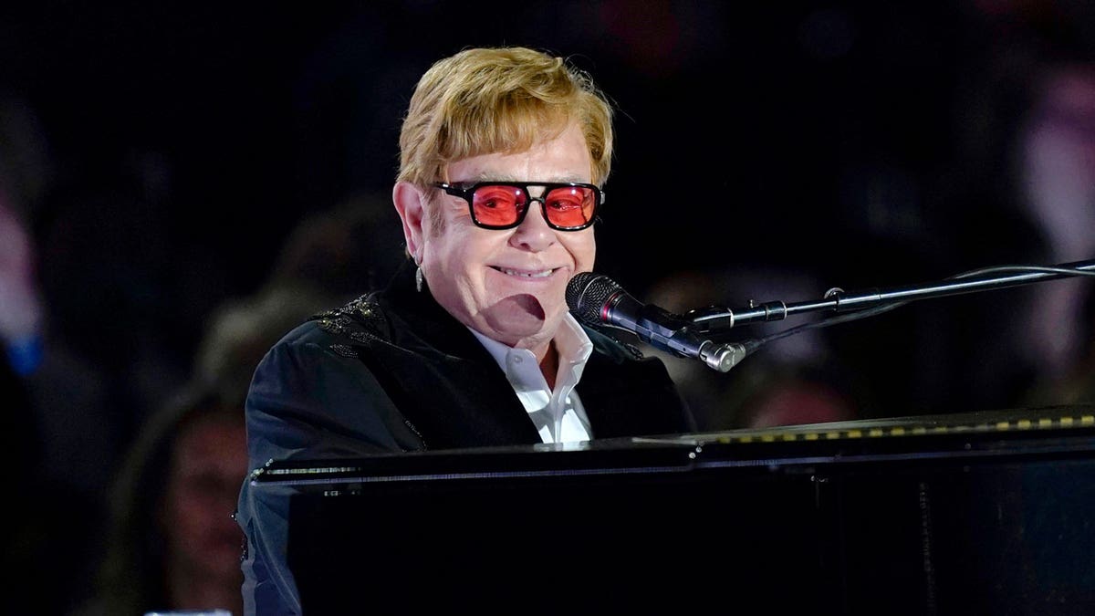 Elton John playing the piano on stage