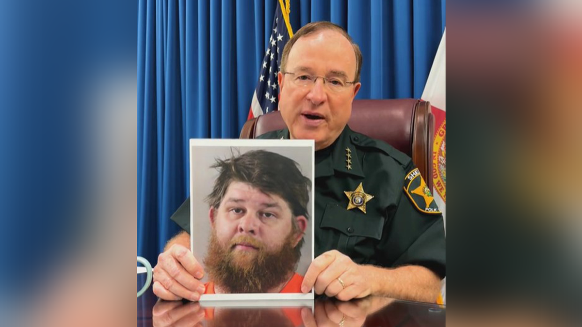 Polk County Sheriff Grady Judd holds up Eric Proctor's mugshot.