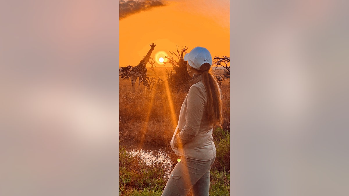 Woman on safari with giraffe