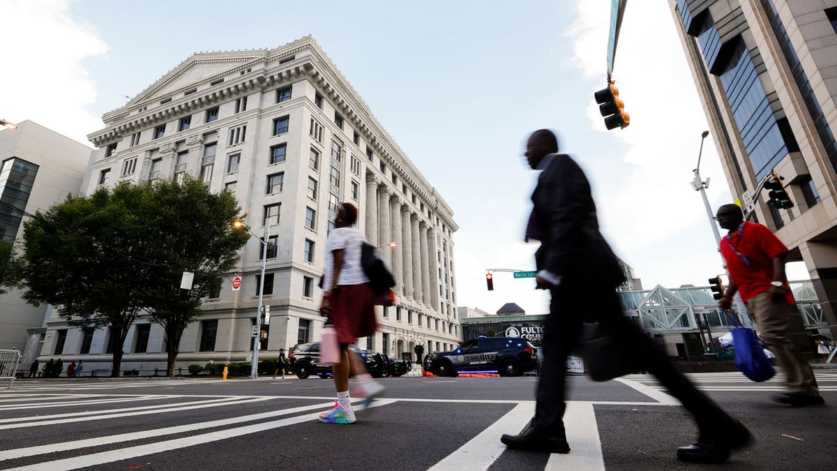 People cross the street near the Fulton County Courthouse in Atlanta