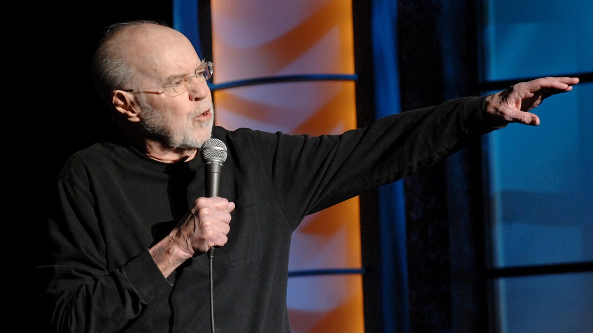 George Carlin holding microphone