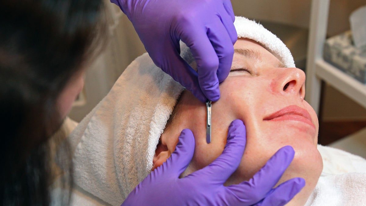 Professional doing dermaplaning on a patient