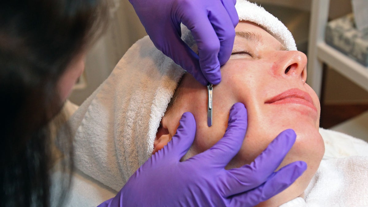 Professional doing dermaplaning on a patient