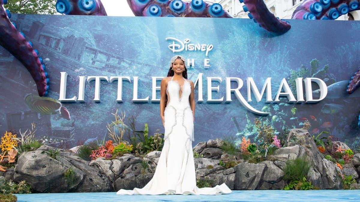 Halle Bailey in front of "The Little Mermaid" sign