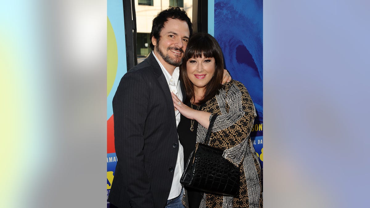 rob bonfiglio and carnie wilson hugging on red carpet