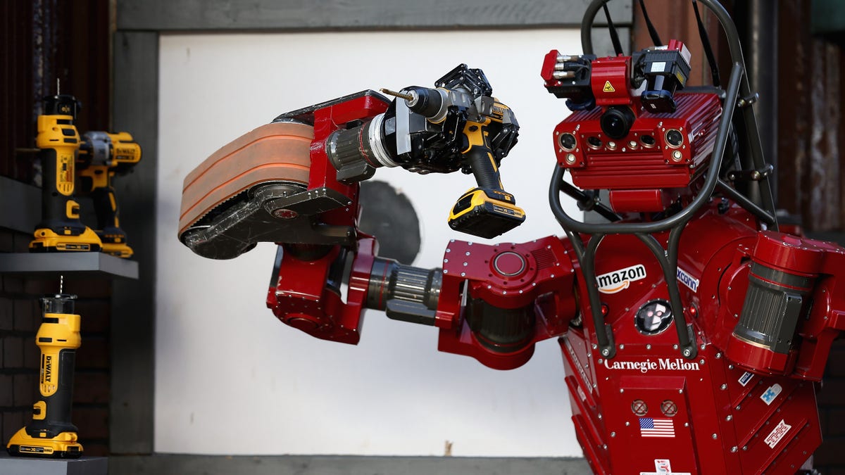 red AI robot holding a drill