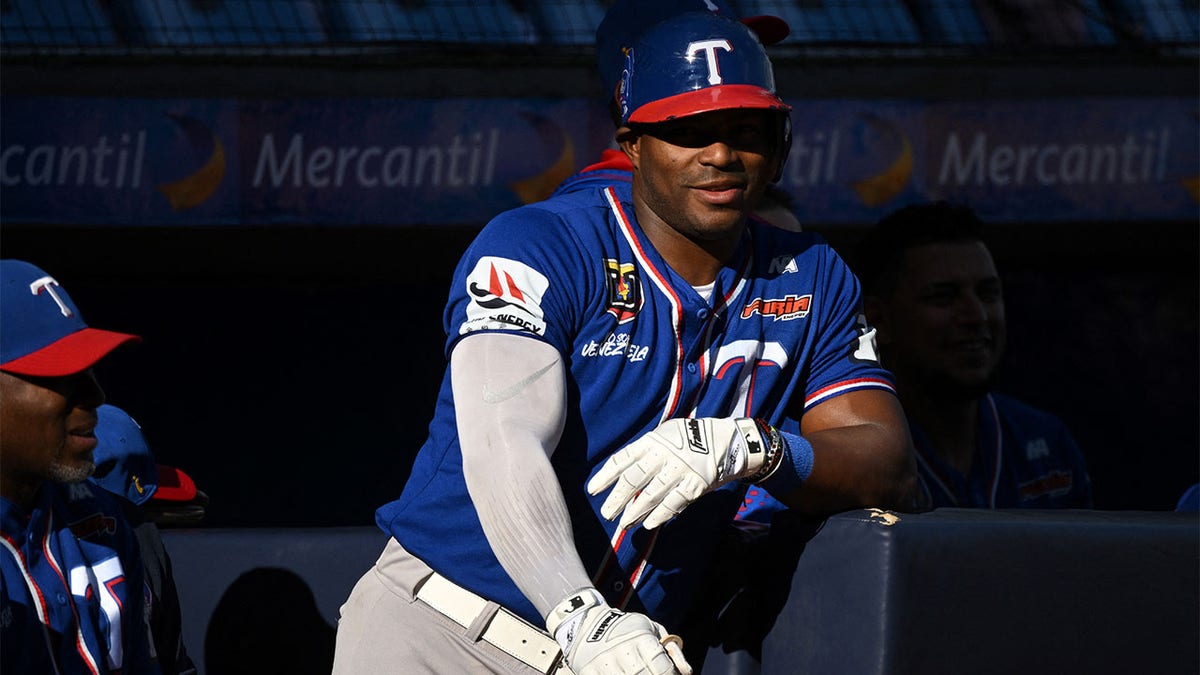 Yasiel Puig watches from the dugout