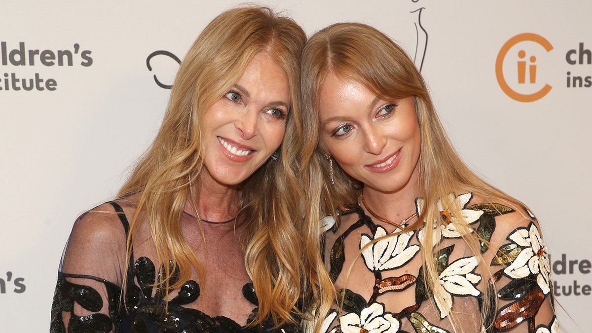 Catherine Oxenberg and India Oxenberg leaning on each other and smiling