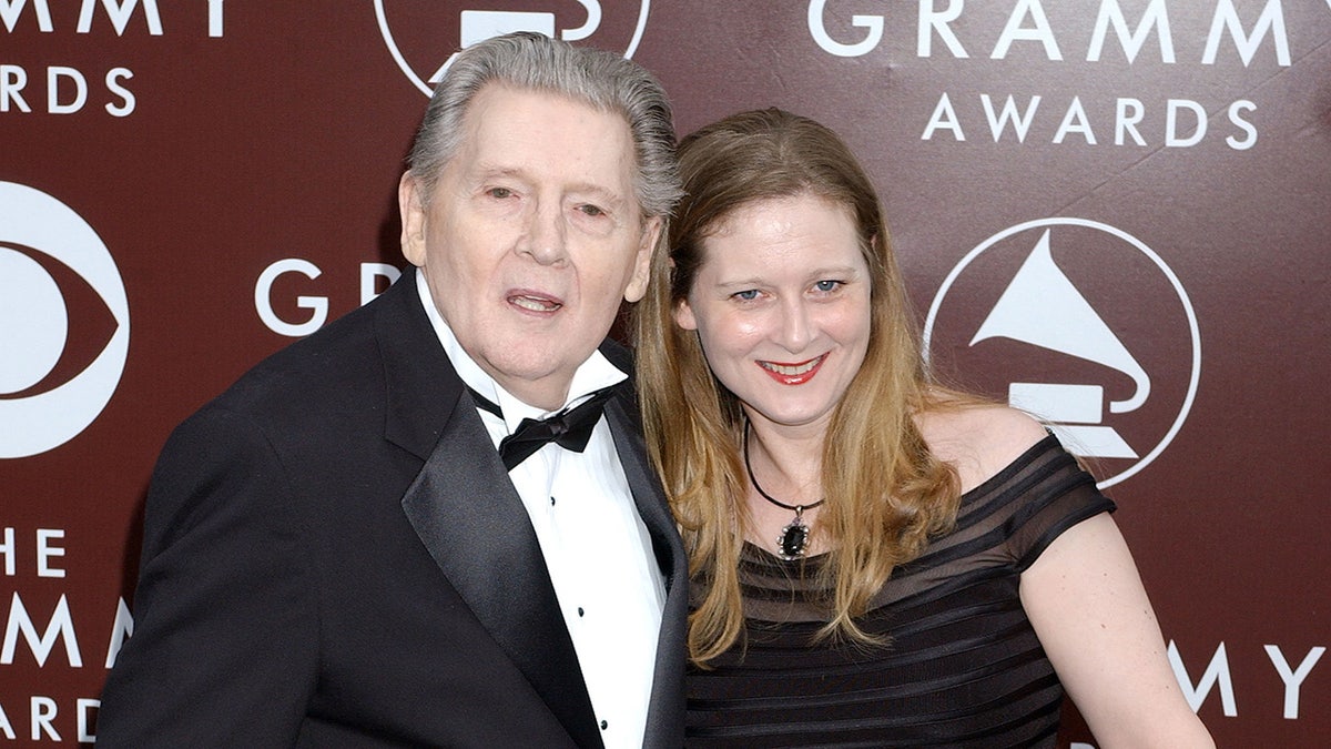 Jerry Lee Lewis leaning next to his daughter Phoebe wearing a black dress