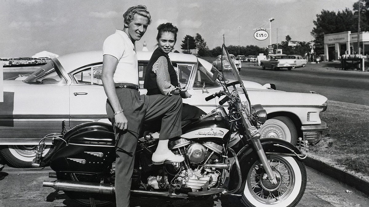 Myra Lewis sitting on a motorcycle next to Jerry Lee Lewis