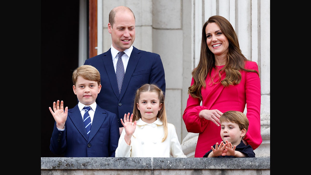 Prince William and Kate Middleton standing on the palace balcony with their three children