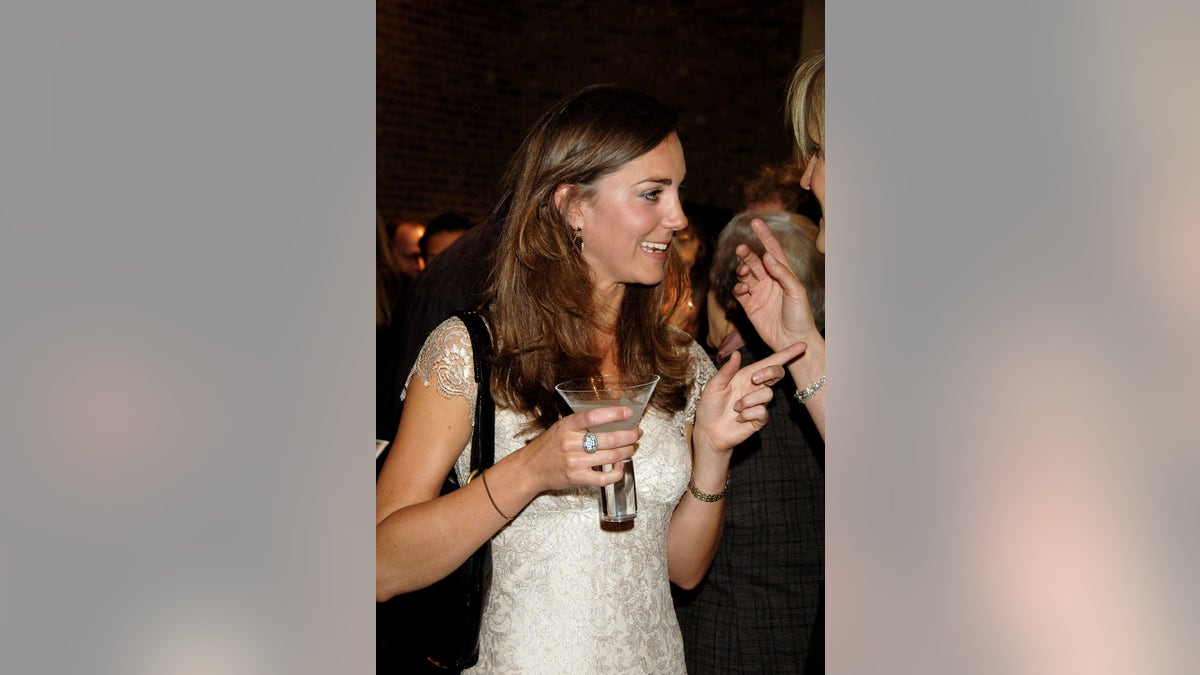 Kate Middleton holding onto a cocktail and pointing at someone