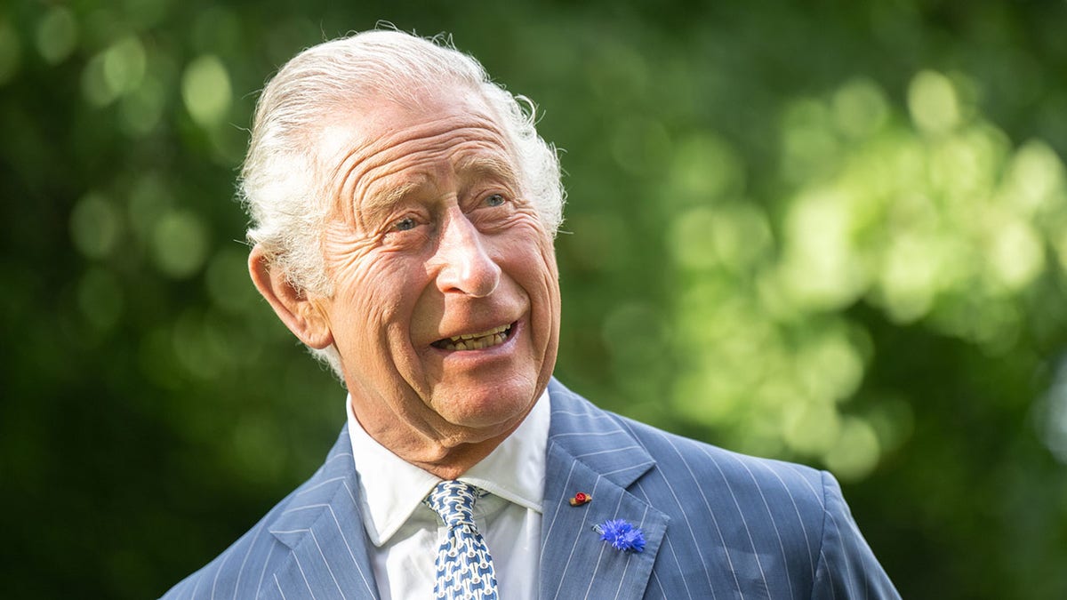 King Charles III smiling in a light blue suit