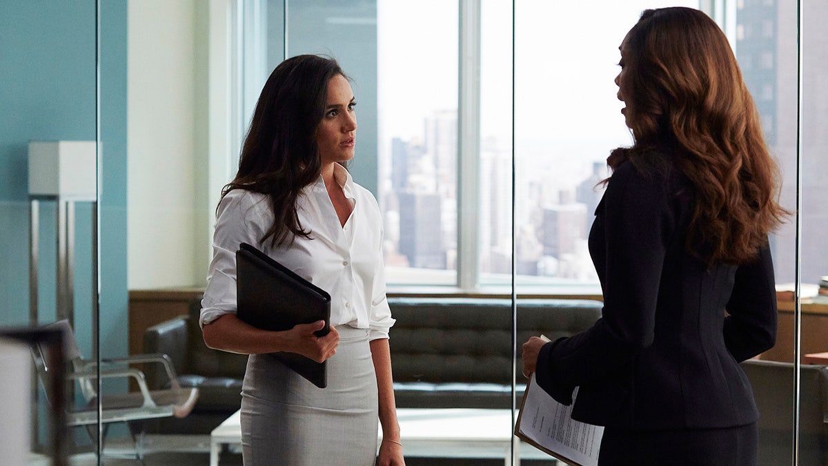 Meghan Markle in character speaking with Gina Torres