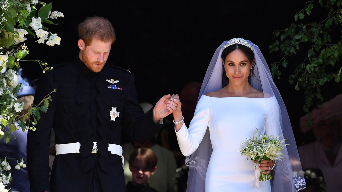 Prince Harry holding Meghan Markles hand on their wedding day