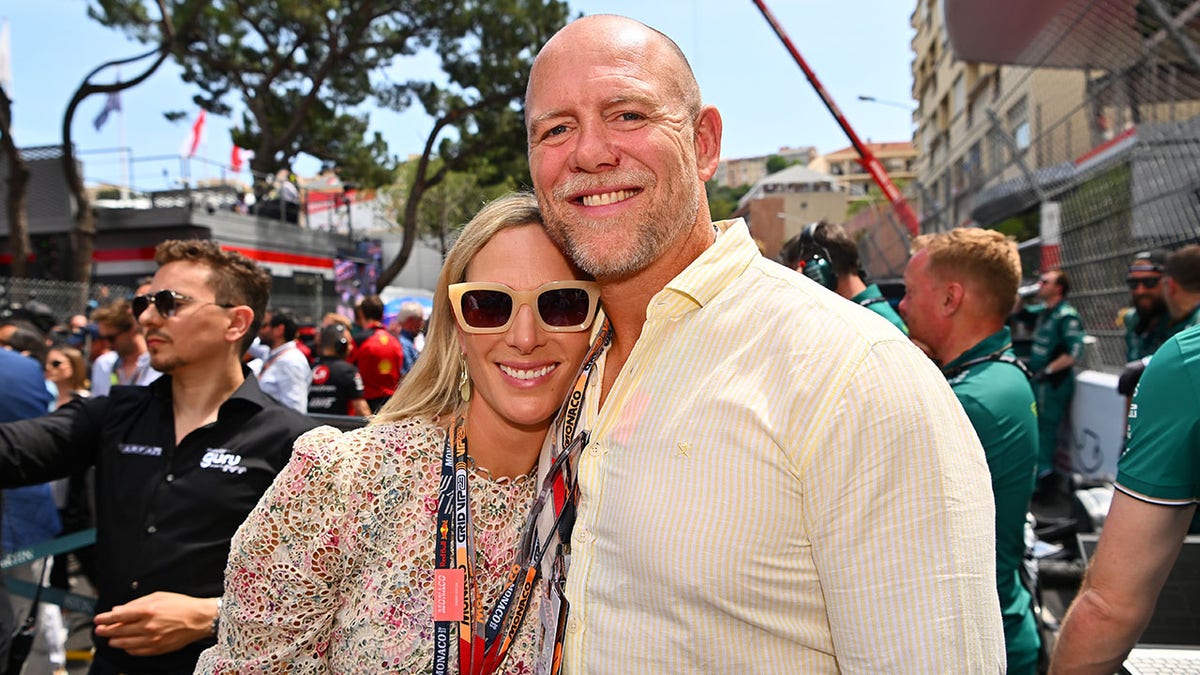 Zara Tindall smiling and wearing sunglasses leaning against a smiling Mike Tindall