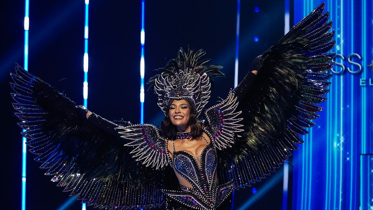 Sheynnis Palacios poses in a sparkling dark costume with wings to represent her home country