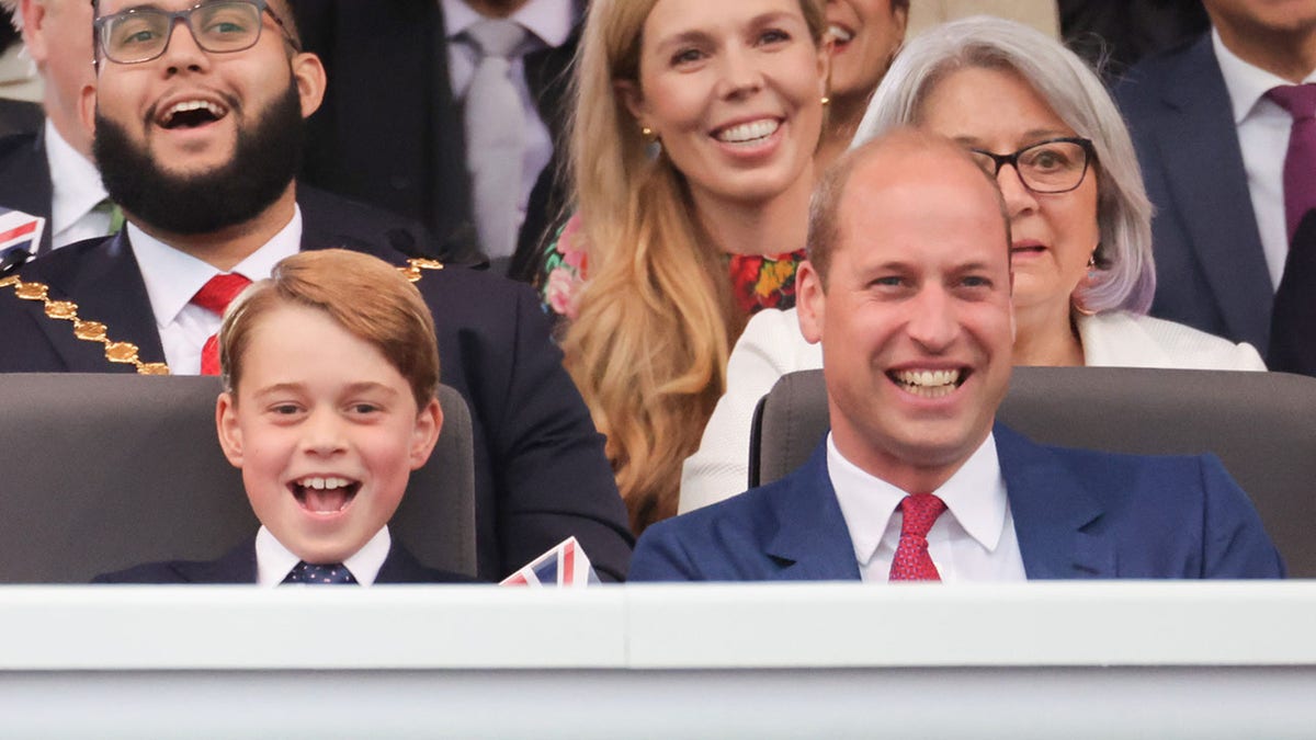 Prince William smiling next to his son Prince George