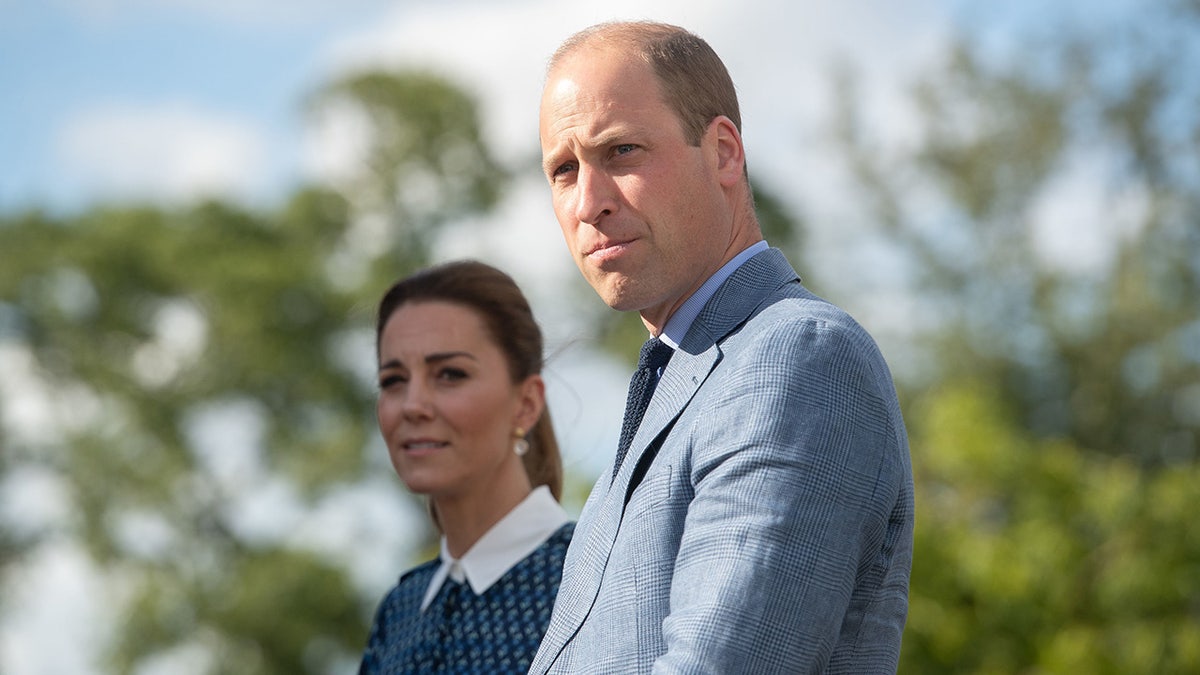 Prince William looking serious next to Kate Middleton