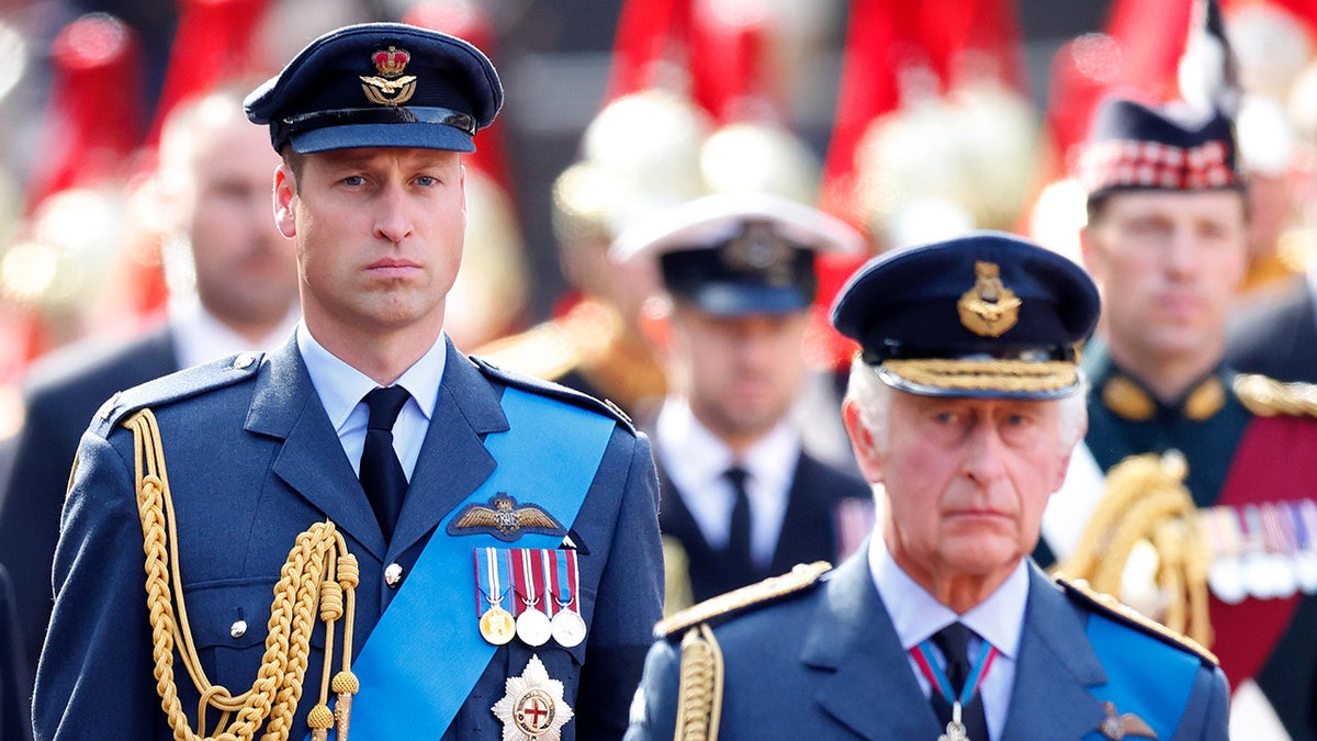 Príncipe William ao lado de seu pai, o rei Charles, enquanto os dois usam uniformes militares
