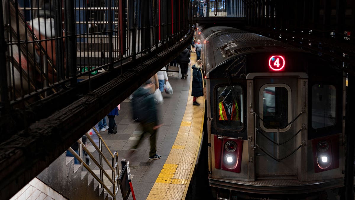 Passengers get on a loud subway in New York City